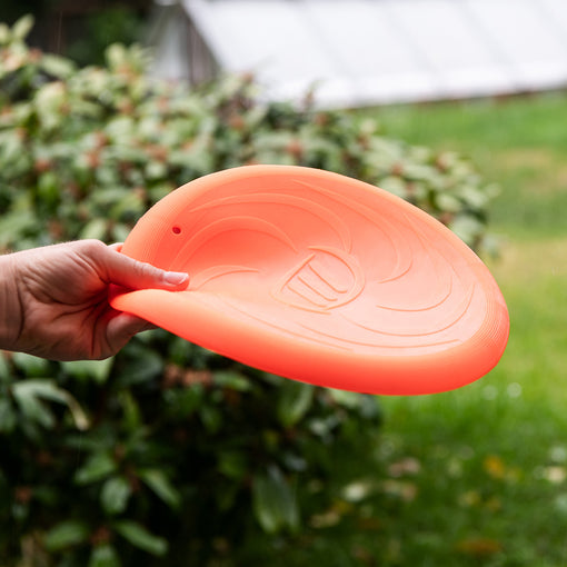 Person hält die biegsame Soft Frisbee MOBY in der Farbe Orange in der Hand 