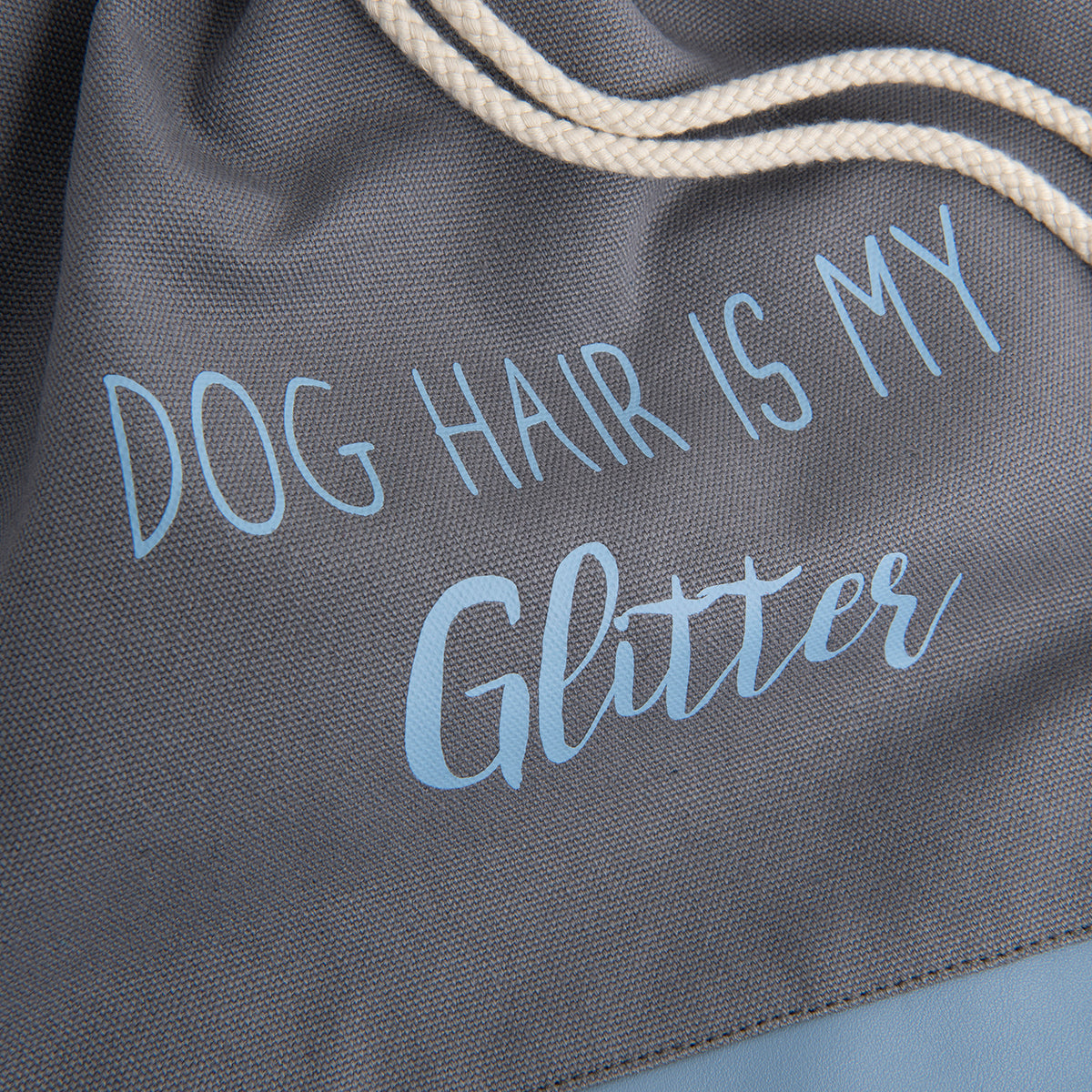 Fokus auf dem Aufdruck des Rucksackbeutels „DOG HAIR IS MY Glitter“ in der Farbe Hellblau 