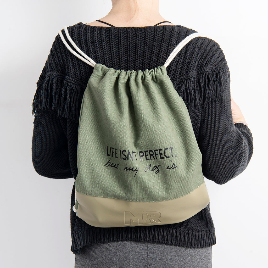 Frau trägt den Rucksackbeutel "Perfect" mit dem doppelten Kordelzug in der Farbkombination Dunkelgrün-Khaki auf dem Rücken